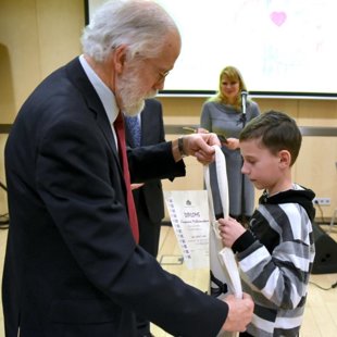 Valdis Rūmnieks apbalvo Kasparu Miklašonoku Dzimtās valodas pasākumā LNB 2017. gada februā